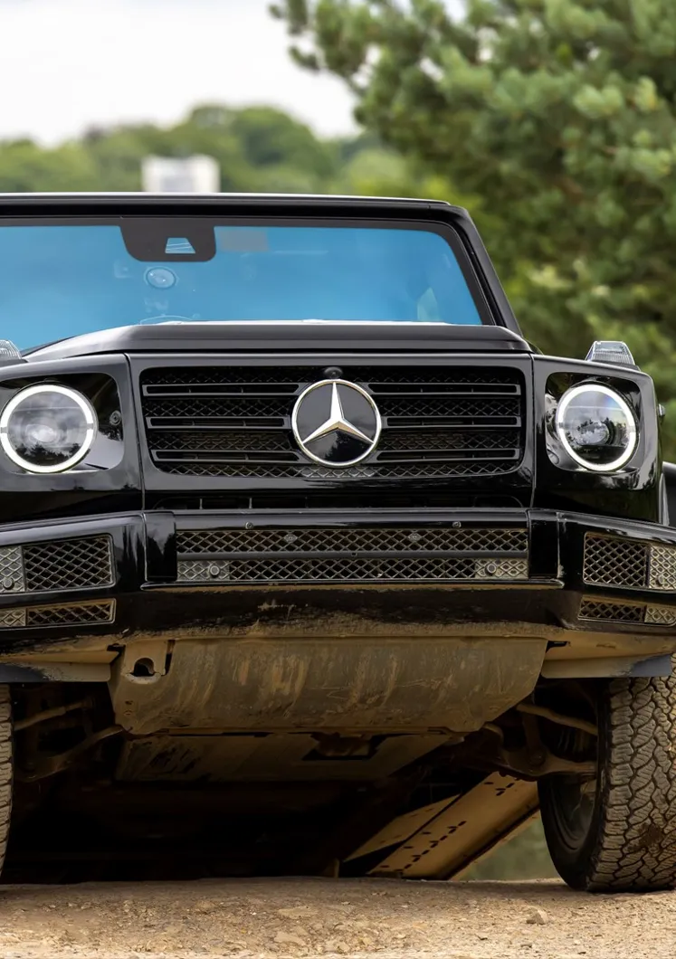 Passenger enjoying a thrilling 4x4 ride through rugged terrain at Mercedes-Benz World's Off-Road Circuit, showcasing vehicle capability and adventure.
