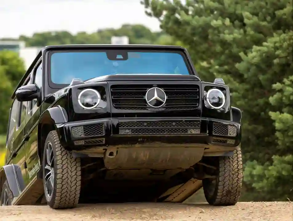 Passenger enjoying a thrilling 4x4 ride through rugged terrain at Mercedes-Benz World's Off-Road Circuit, showcasing vehicle capability and adventure.